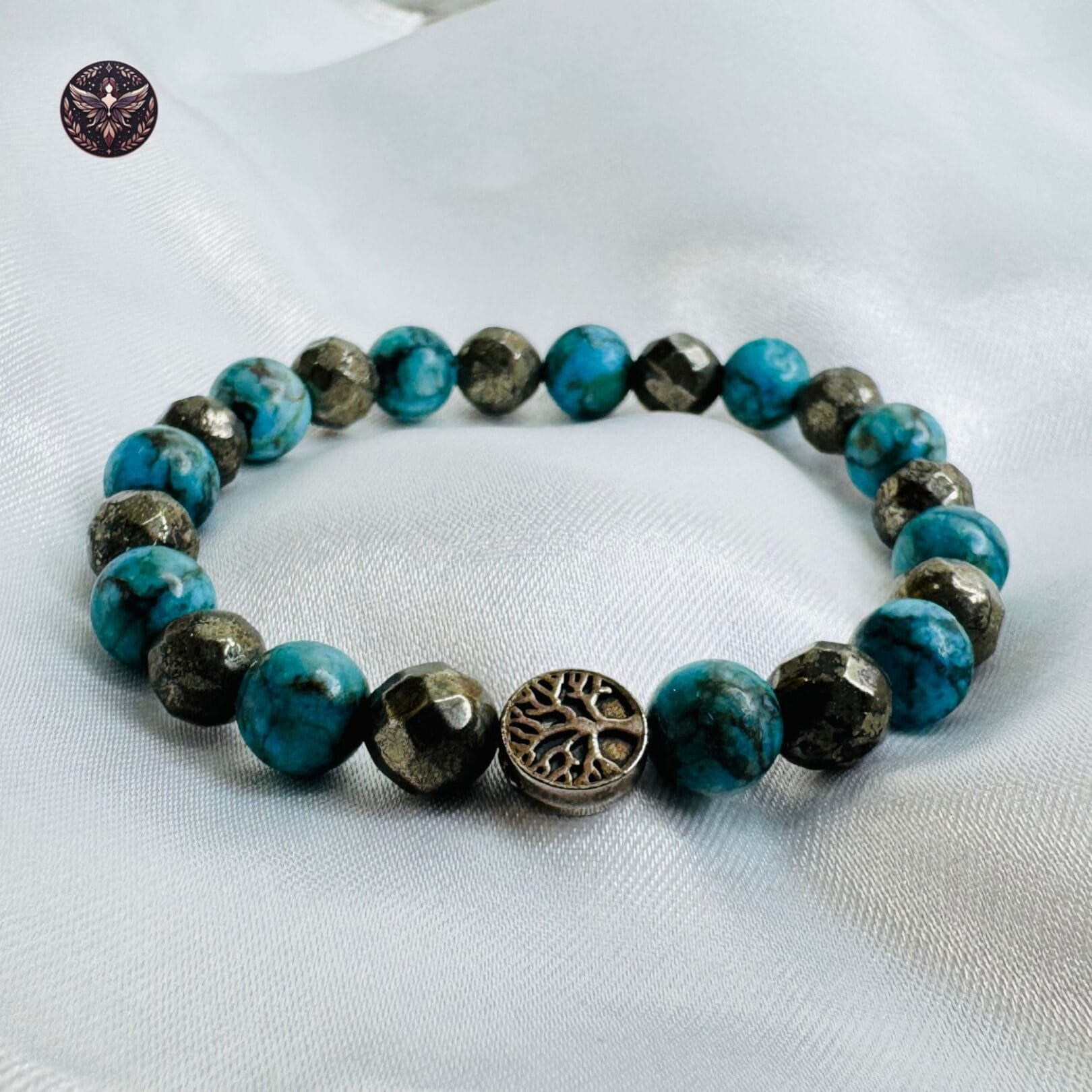Pyrite and Turquoise Opportunity Magnet Bracelet with charm displayed on white satin background